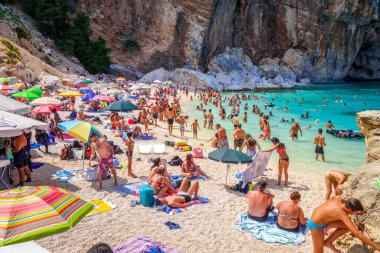 Sardinya / İtalya - 26 Ağustos 2019 - Orosei Golfü 'ndeki Cala Mariolu plajında bir grup turist