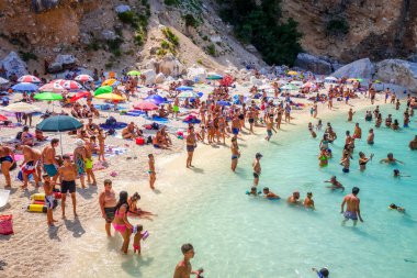 Sardinya / İtalya - 26 Ağustos 2019 - Orosei Golfü 'ndeki Cala Mariolu plajında bir grup turist
