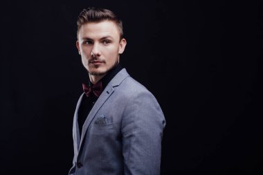 Koyu arka plan üzerinde dört gözle gri ceketli güzel çocuk