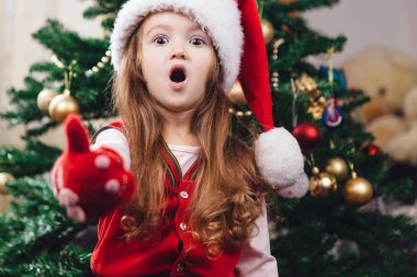 Kırmızı Noel şapkalı sürpriz neşeli kız