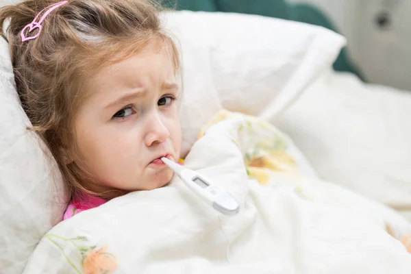 Gadis kecil yang sakit memegang termometer — Stok Foto