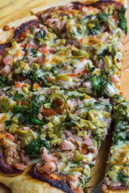 Rustik ahşap bir masa üzerinde taze pizza servis.