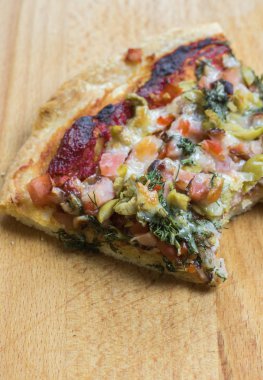 Rustik ahşap bir masa üzerinde taze pizza servis.