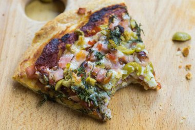 Rustik ahşap bir masa üzerinde taze pizza servis.