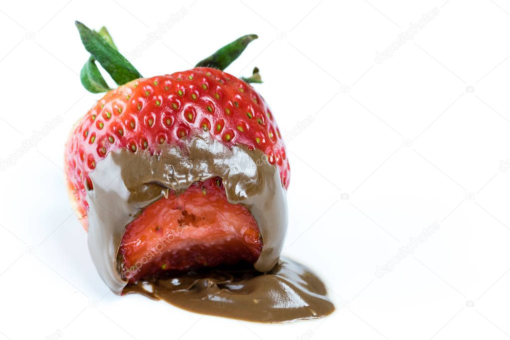 Bite of juicy strawberry covered in chocolate