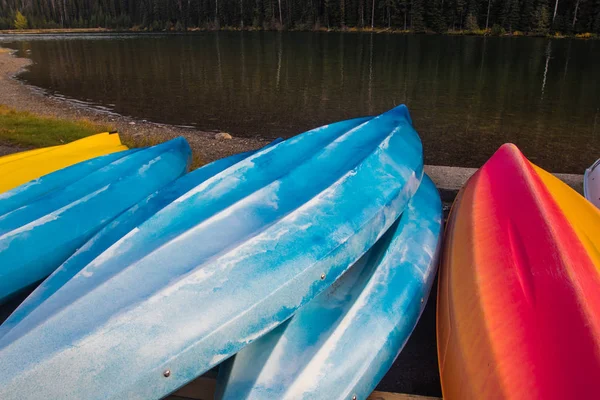 Colorful kayaks on a lake shore — Stock Photo, Image