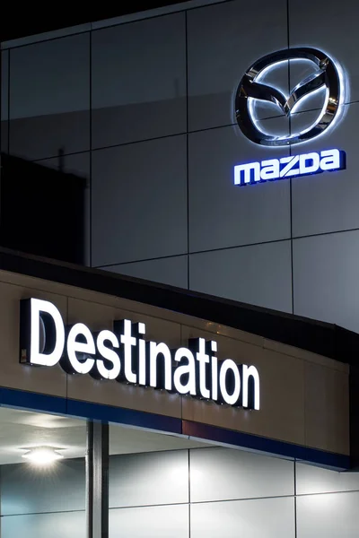 Vancouver. Canada - January 9, 2018: Mazda logo on the facade of official dealer office. Mazda Motor Corporation is a Japanese car brand, automotive manufacturer. Night shot with logos illuminated. — Stock Photo, Image