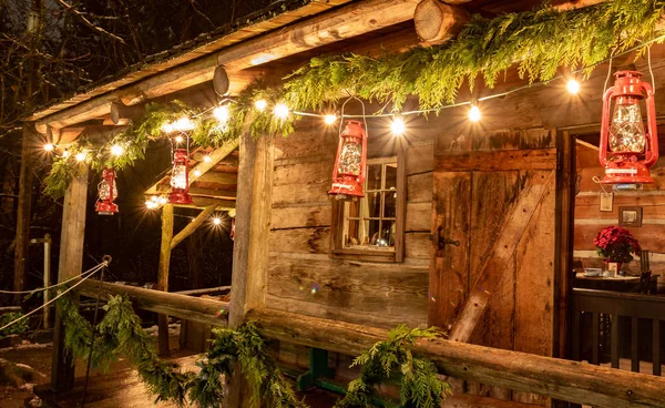 Mały i przytulny domek kabina na zewnątrz z lampkami świątecznymi. Idealny obraz, który przywołuje ducha wakacji. — Zdjęcie stockowe