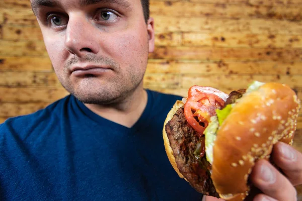 Fast food burgeriyle mutlu bir adam. Pek sağlıklı bir yaşam tarzı değil ama neyse.! — Stok fotoğraf