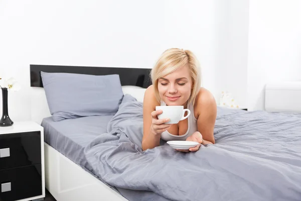 Woman cup of coffee smell closed eyes dream on bed — Φωτογραφία Αρχείου