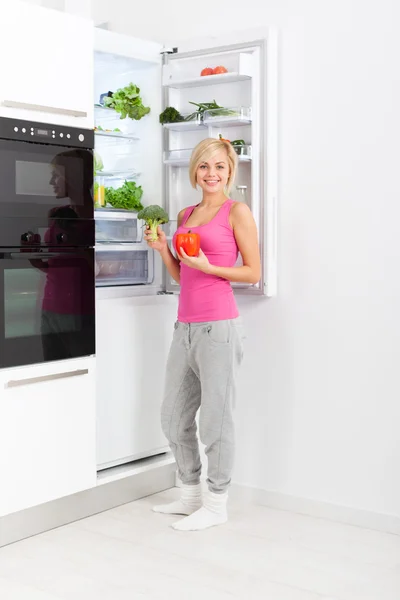 Woman drink orange juice hold glass refrigerator — Stockfoto