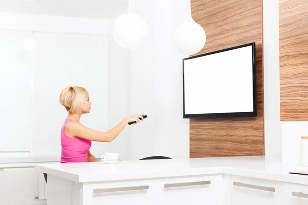 Frau im Fernsehen hält Fernbedienung in der Hand — Stockfoto