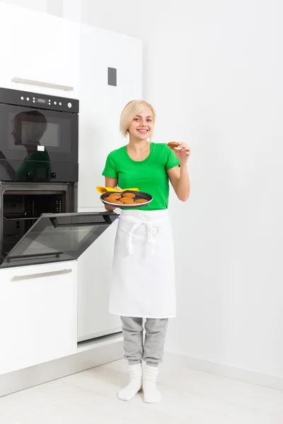 Woman cooking taste cookies baking oven tray — Stok fotoğraf