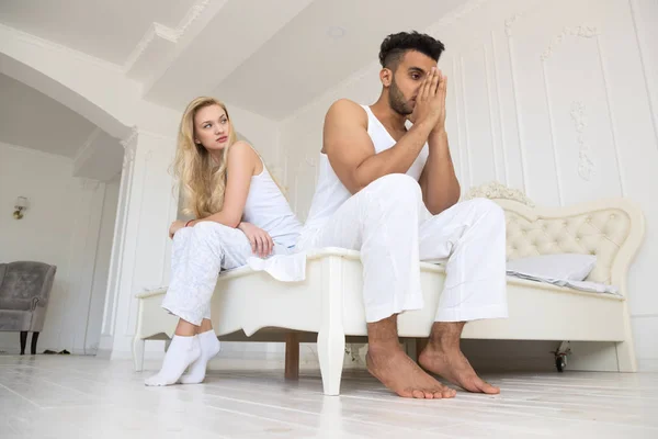 Casal jovem sentado separado na cama — Fotografia de Stock