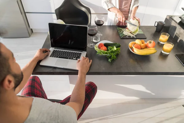 Young Couple Having Breakfast, Mman Using Laptop Computer Woman Cooking Food Kitchen — Stock Photo, Image