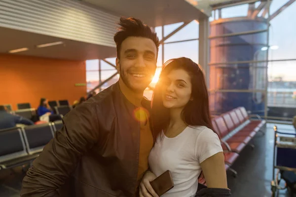Casal jovem no aeroporto Lounge esperando partida Sorriso feliz hispânico homem e mulher — Fotografia de Stock