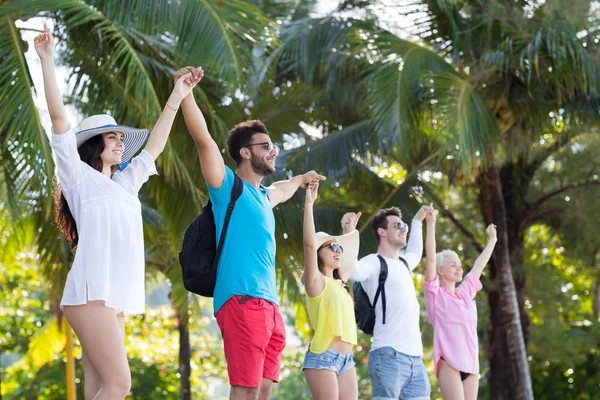 Junge Leute Gruppe hält Hände hoch tropischen Park Palmen glücklich lächelnde Freunde Urlaub Sommerferien — Stockfoto