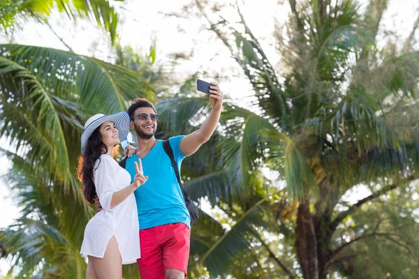 Pareja tomar selfie foto tropical playa palmeras vacaciones de verano, gente joven hermosa, hombre mujer sonrisa feliz —  Fotos de Stock