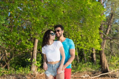 Çift, tropikal yeşil orman yaz tatili kucaklayan güzel genç aşıklar, adam kadını mutlu gülümseme