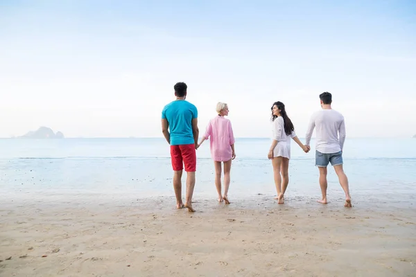 Grupo de jovens em férias de verão na praia, amigos andando à beira-mar Voltar Visão traseira — Fotografia de Stock