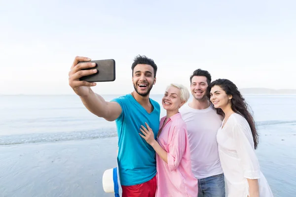 年轻人们组自拍照合影在单元格上的海滩上智能手机的暑假，快乐微笑朋友海假日 — 图库照片