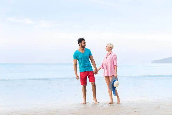 Par på sommaren strandsemester, vackra unga glada människor i kärlek promenader, Man kvinna leende hålla händerna — Stockfoto