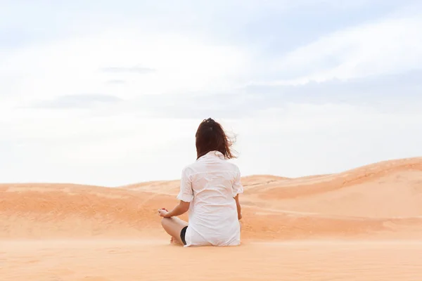 Nő a sivatagban ülő Lotus jelentenek fiatal lány meditál homokdűne háttér — Stock Fotó