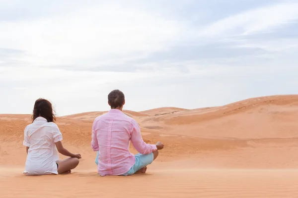 Mężczyzna i kobieta w pustynia siedzący Lotus stanowią Młoda para medytacji — Zdjęcie stockowe