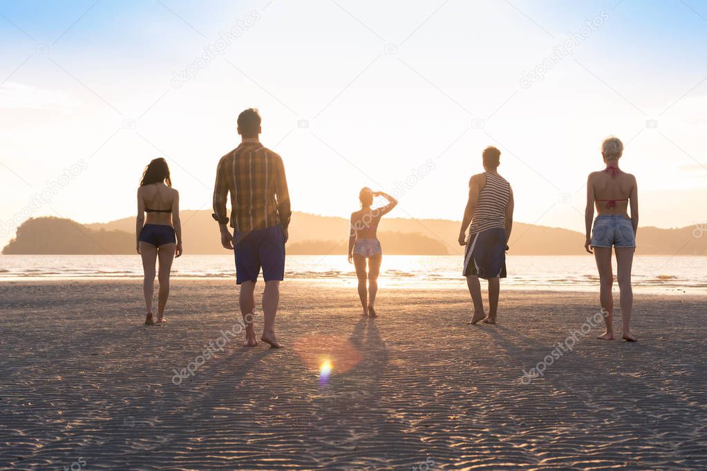 Young People Group On Beach At Sunset Summer Vacation, Friends Walking Seaside Back Rear View