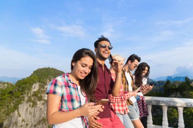 Genç insanlar grubu hücre kullanarak dağ akıllı telefon sohbet Online arkadaşlar Asya tatil yaz