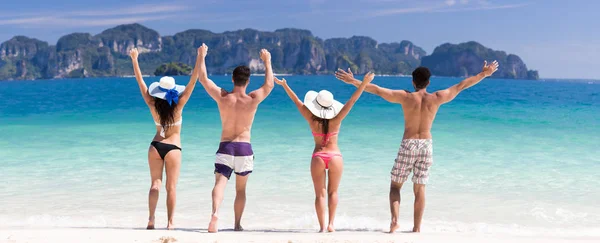 Jugendgruppe im Sommerurlaub am Strand, zwei Paar hob die Hände Freunde am Meer — Stockfoto