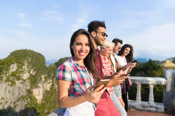 Mladí lidé skupiny v Mountain buňka inteligentní telefon chatování Online přátelé asijské dovolená léto — Stock fotografie