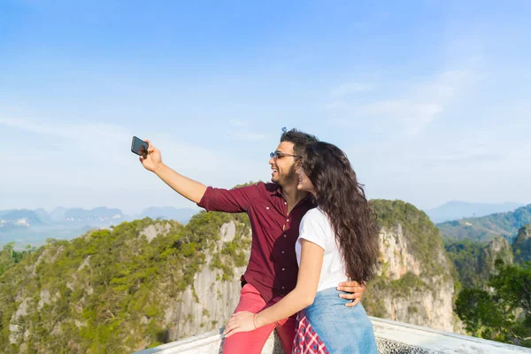 Jovem casal montanha vista ponto feliz sorridente homem e mulher tomando selfie foto no celular inteligente telefone asiático feriado — Fotografia de Stock