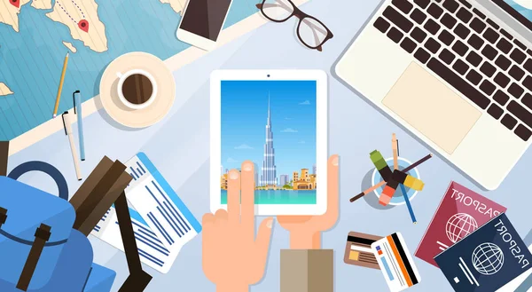 Hand Hold tabletcomputer met Dubai Skyline Panorama, reiziger werkplek met paspoorten Top hoekmening — Stockvector