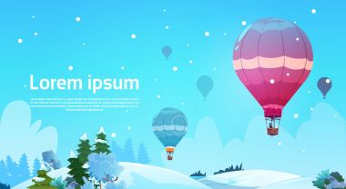 Kışın kar peyzaj üzerinde gökyüzünde uçan renkli hava balonları