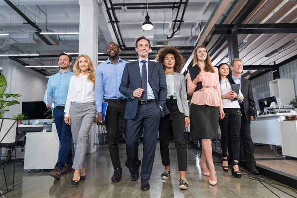 Business-Team promenader Office Full längd, företagare grupp med ledare i förgrunden rör sig framåt genom moderna kreativa utrymme — Stockfoto