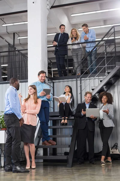 Grupp av affärsmän som arbetar tillsammans med trappa, framgångsrikt Team diskuterar nya projektstrategi i moderna Open Space Office Mix Race företagare — Stockfoto