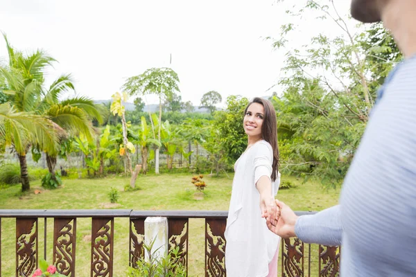 Mulher líder homem segurando a mão no terraço de verão com bela paisagem de madeira verde feliz sorrindo jovem casal — Fotografia de Stock