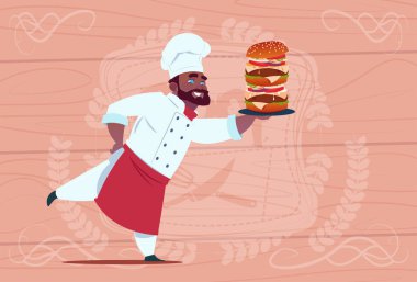 Afrikalı Amerikalı şef aşçı tutun Big Burger karikatür Restoran şefi beyaz üniformalı ahşap dokulu arka plan üzerinde gülümseyen