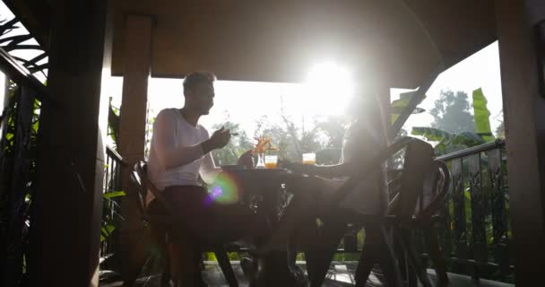 Пара завтраков на летней террасе, общение между мужчиной и женщиной, наслаждаясь здоровой едой на открытом воздухе утром — стоковое видео