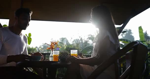 夏のテラスで朝食を食べるカップル、男と女のコミュニケーションしながら健康的な食事を楽しんで屋外朝 — ストック動画