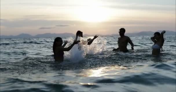 Groep vrienden zwemmen In de zee bij zonsondergang mensen spetteren In Water plezier — Stockvideo