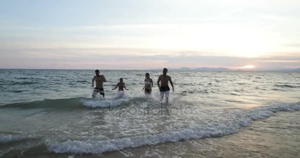 Grupy osób prowadzących od wody morza, młodzi przyjaciele Mix wyścigu na plaży o zachodzie słońca, zabawy wesoły mężczyźni i kobiety podczas letnich wakacji — Wideo stockowe