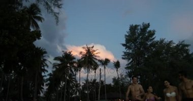 Neşeli grup günbatımı, iki yarış çift turist sahil üzerinde karıştırmak sonra Sahilde yürüyüş konuşurken insan