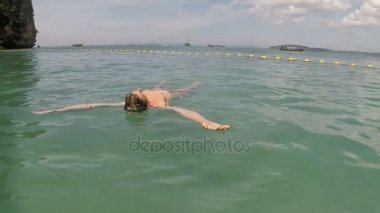 Adam Yüzme deniz eylem kamera Pov su güzel plajda yatan genç adam arkada üzerinde