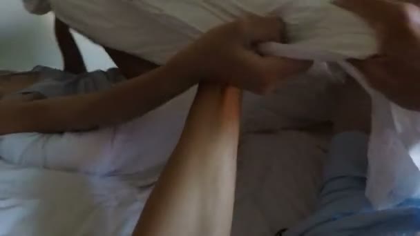 Красива жінка прокидається чоловік бере ковдру в ліжку вранці POV Молода пара Боротьба подушки — стокове відео