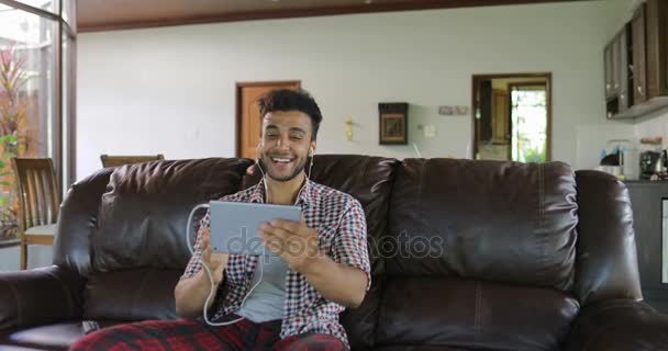 Ο άνθρωπος κάνει Online βίντεο κλήση χρησιμοποιώντας Tablet υπολογιστή κάθονται στο πούλμαν στο σαλόνι, Λατινική τύπος μιλώντας για επικοινωνία μέσω Διαδικτύου — Αρχείο Βίντεο