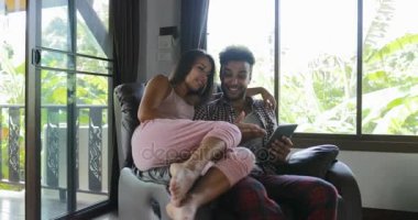 Ekran tarama Online Internet, genç çift evde birlikte kadın ve koltuk kullanan Tablet bilgisayarda, dokunmatik konuşurken oturan adam