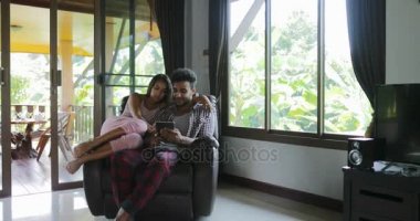 Ekran tarama Online Internet, genç çift evde birlikte kadın ve koltuk kullanan Tablet bilgisayarda, dokunmatik konuşurken oturan adam