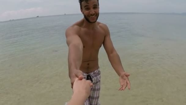 Hispanische Mann laufen in Meerwasser halten Hand Action-Kamera pov von jungen Paar am Meer — Stockvideo